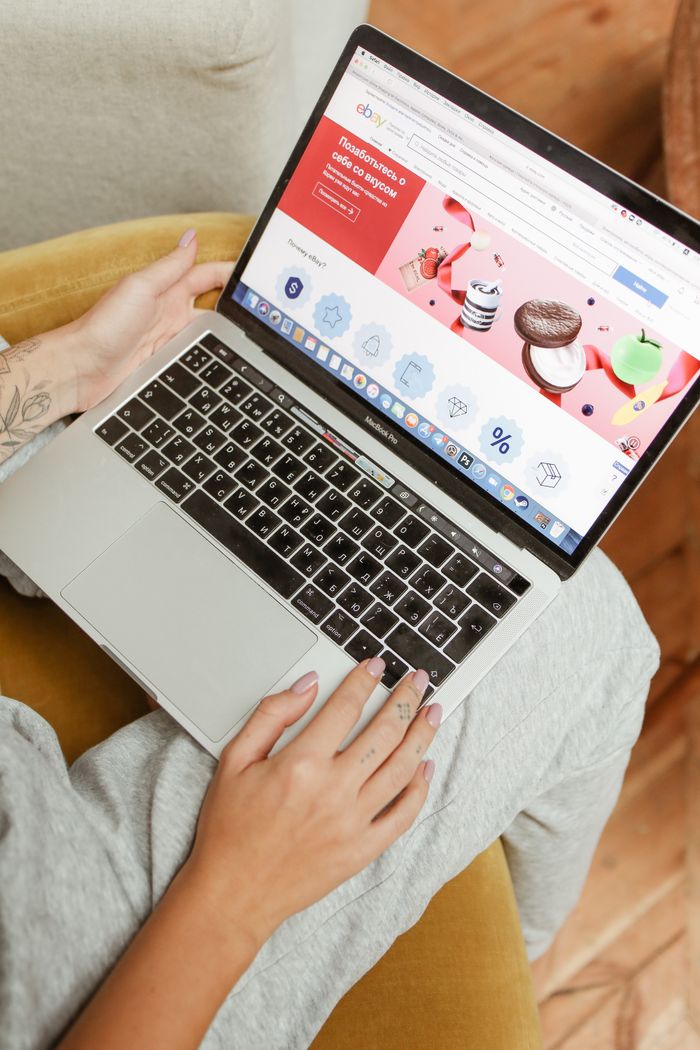 Mastering the First Impression: Your intriguing post title goes here A woman sits comfortably indoors, browsing an online shopping website on her laptop.